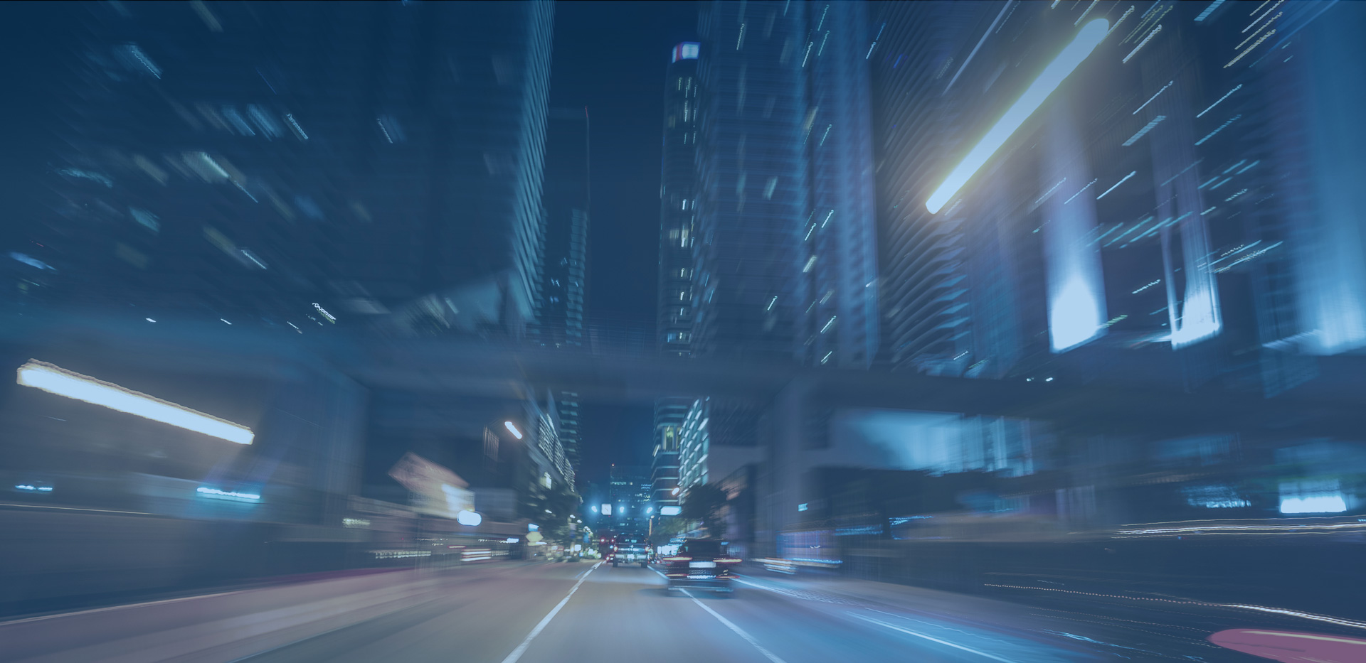a blurred image of a moving object by night with large buildings, in the style of 32k uhd, speed and motion, dark gray and aquamarine, streamlined design, street scene